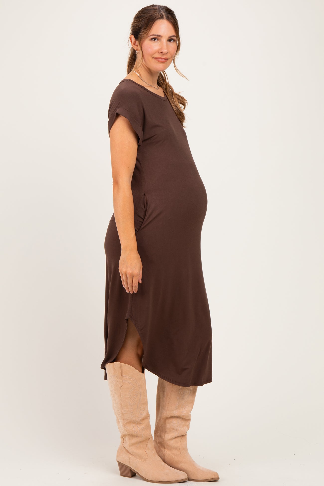 woman wearing a brown short sleeve maternity dress with side slits and a visible baby bump