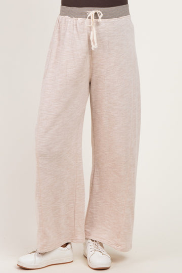 woman wearing light pink wide-leg maternity pants with drawstring waist