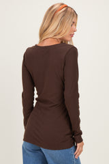 woman wearing a brown long sleeve ribbed top, viewed from the back, paired with light blue jeans