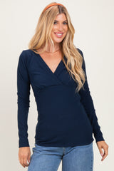 woman wearing a navy long sleeve wrap top with a fitted bodice and v-neckline, styled with casual jeans