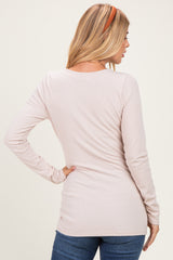 woman wearing a light pink long sleeve top with a ribbed texture and fitted silhouette, seen from the back