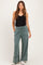 woman wearing a black tank top and green wide-leg maternity pants with pockets