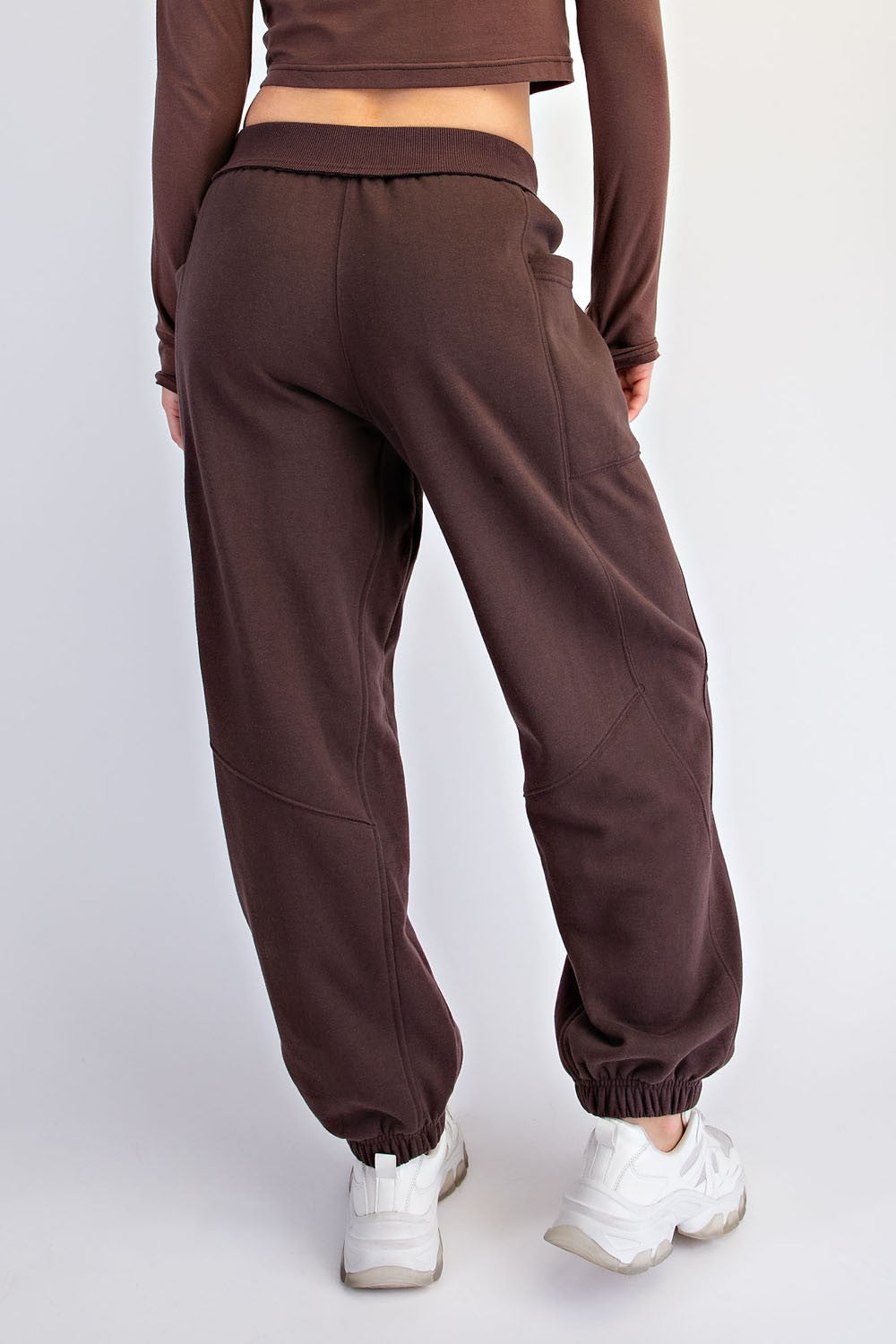 woman wearing brown sweatpants with elastic cuffs and a relaxed fit, showing the back view