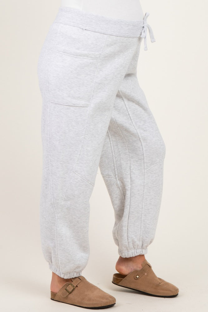woman wearing light gray maternity sweatpants with a drawstring waist and tapered cuffs