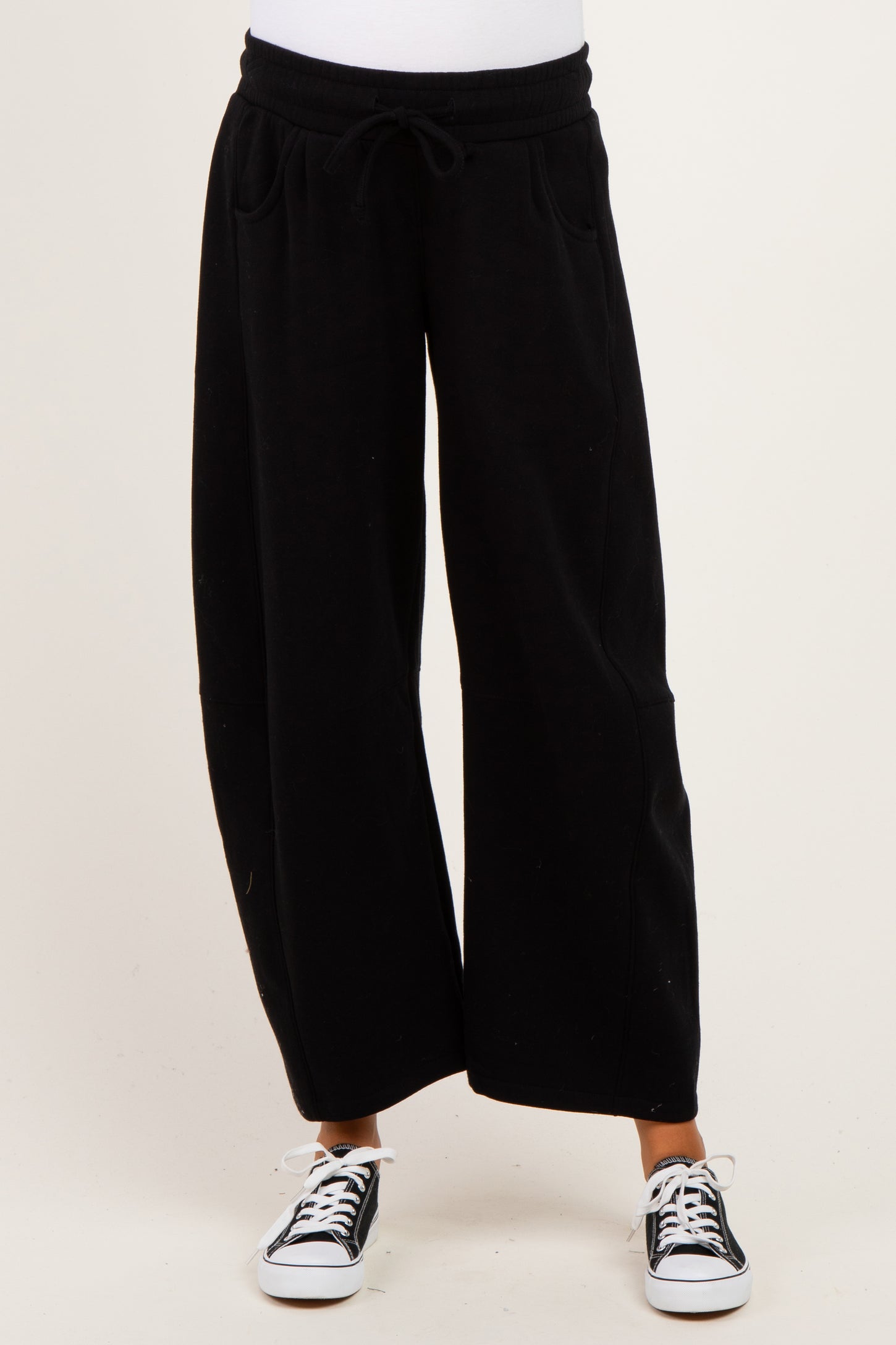 woman wearing black wide-leg maternity sweatpants with an elastic waistband and side pockets