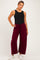 woman wearing a black ribbed tank top and burgundy wide-leg maternity pants, styled for comfort