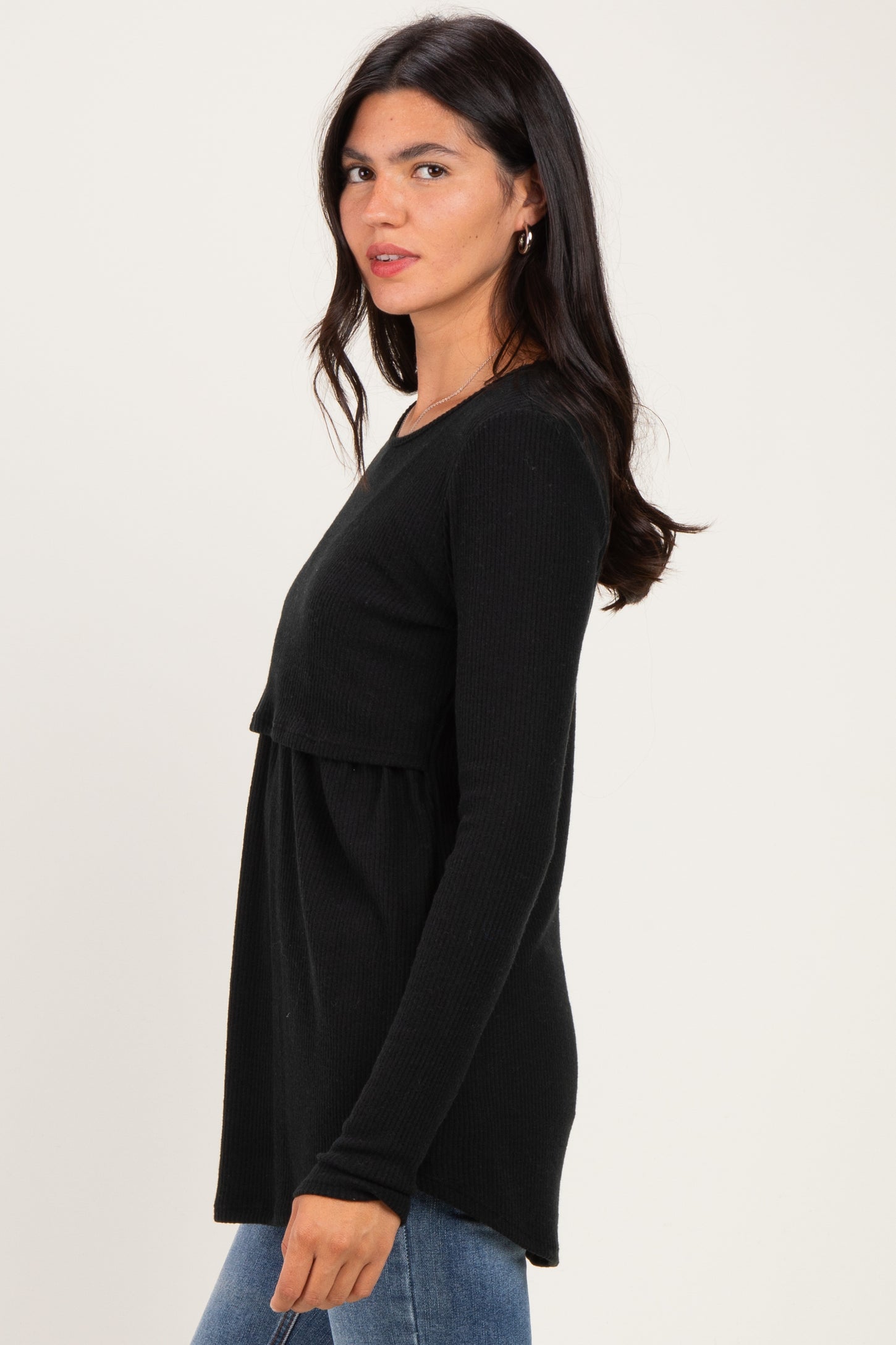 woman wearing a black long sleeve peplum top, styled with a round neckline and relaxed fit