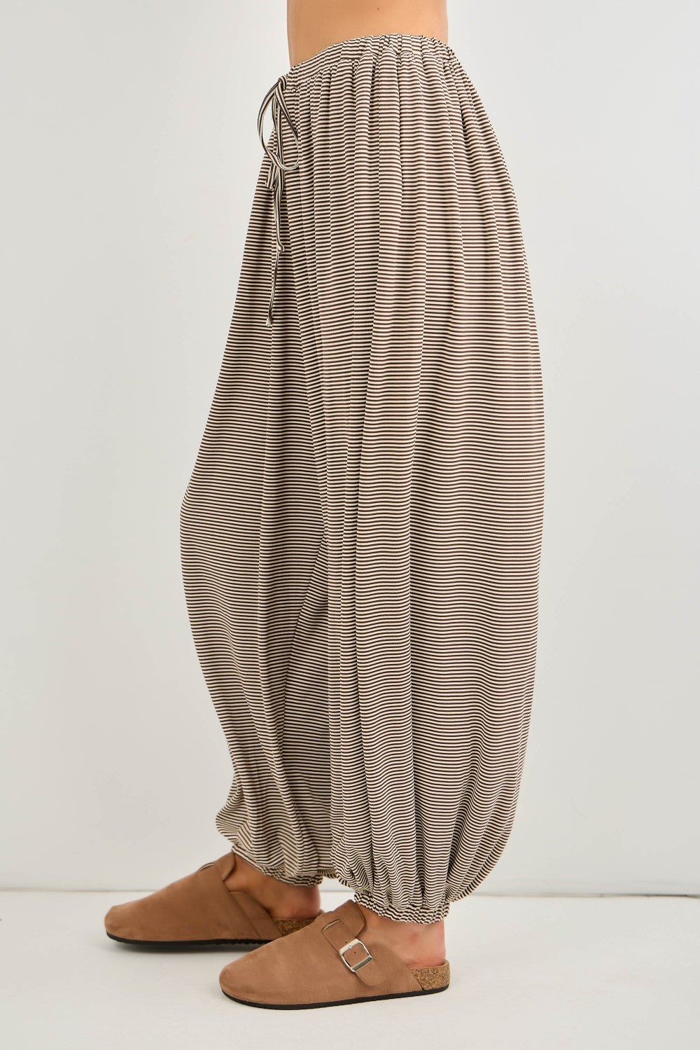 woman wearing beige striped wide-leg pants with an elastic waistband and gathered cuffs