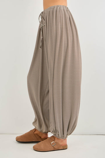 woman wearing beige striped wide-leg pants with an elastic waistband and gathered cuffs