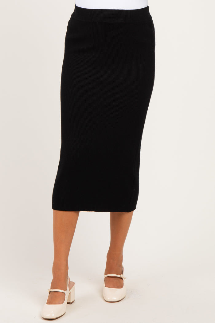 woman wearing a black ribbed maternity skirt with a fitted silhouette and mid-calf length