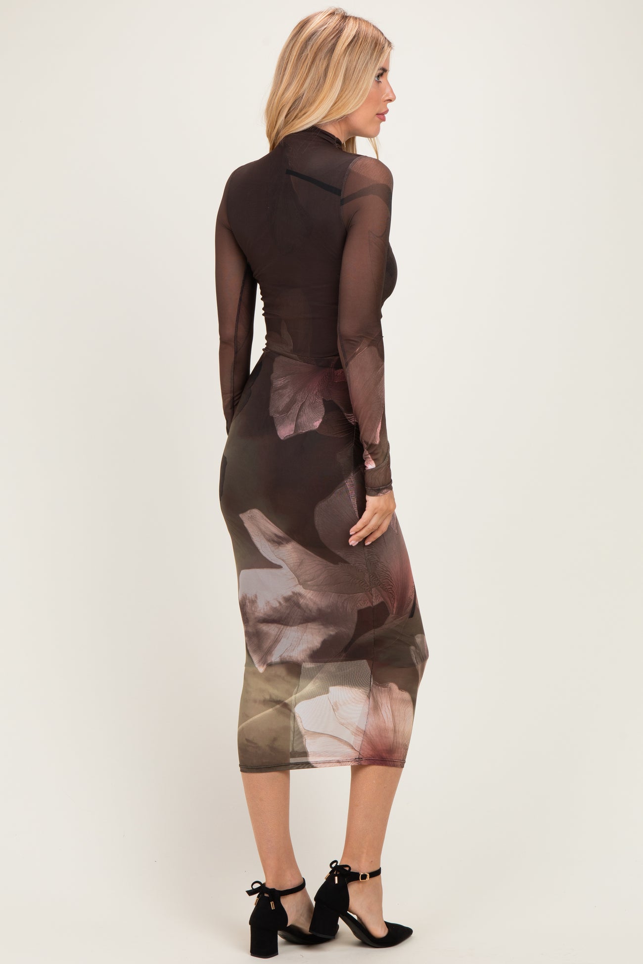 woman wearing a long sleeve bodycon dress with a sheer brown floral design showing a fitted silhouette from the back