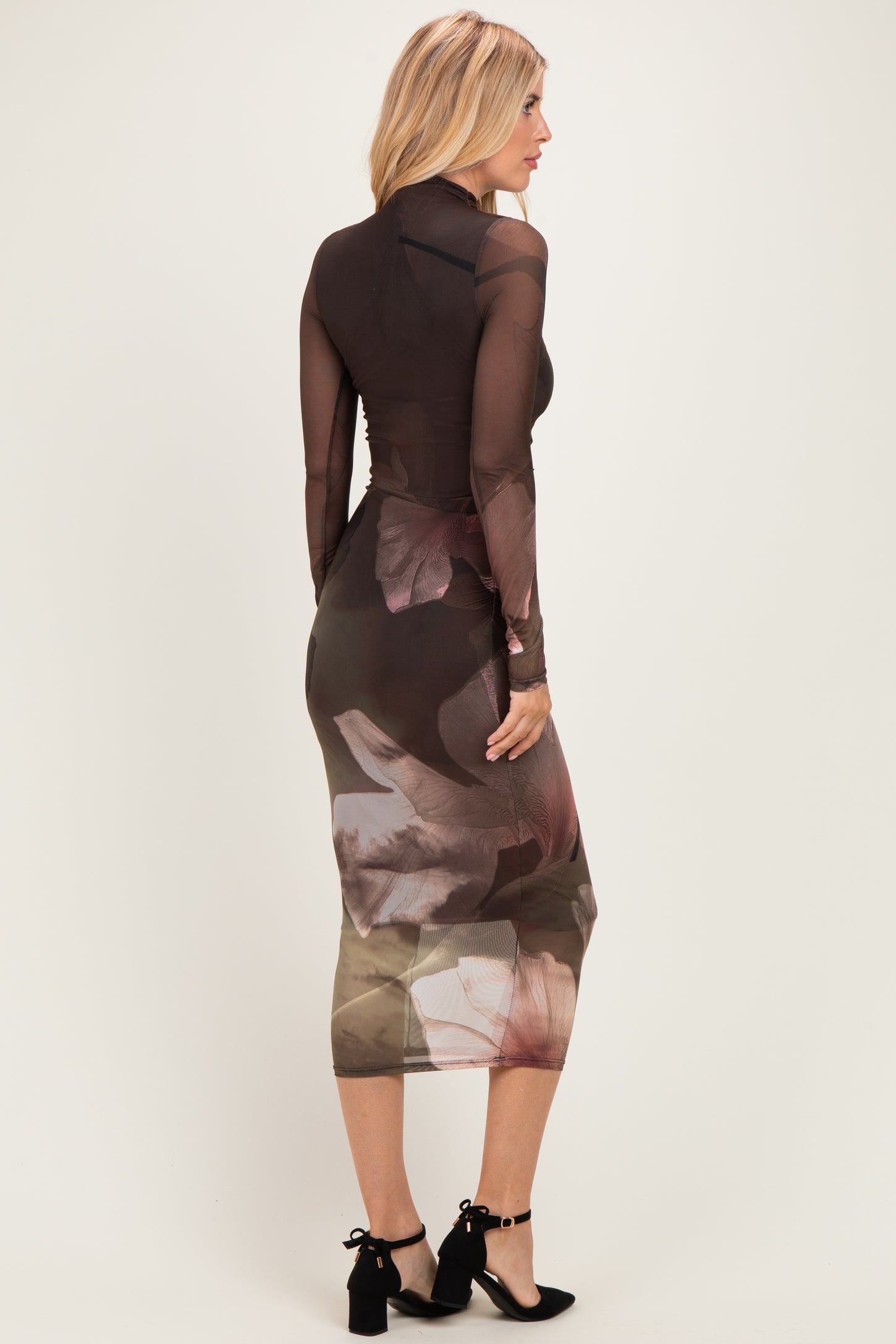 woman wearing a long sleeve bodycon dress with a sheer brown floral design showing a fitted silhouette from the back