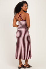 woman wearing a burgundy and white striped midi dress with crisscross straps at the back
