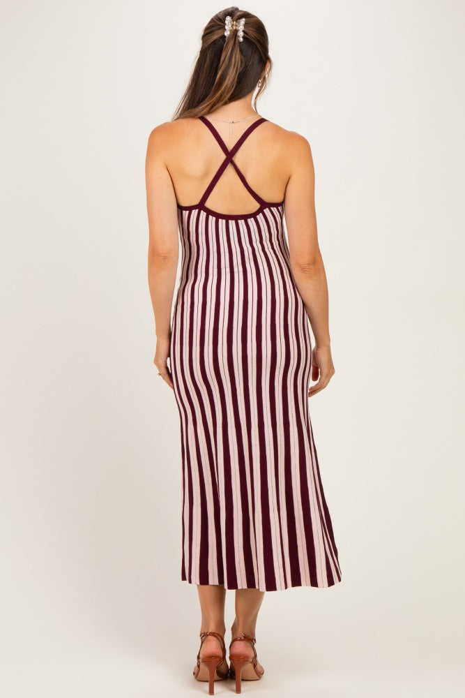 woman wearing a burgundy and cream striped maternity maxi dress with a crisscross back design
