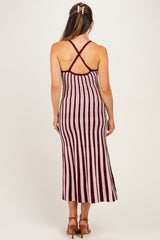 woman wearing a burgundy and cream striped maternity maxi dress with a crisscross back design