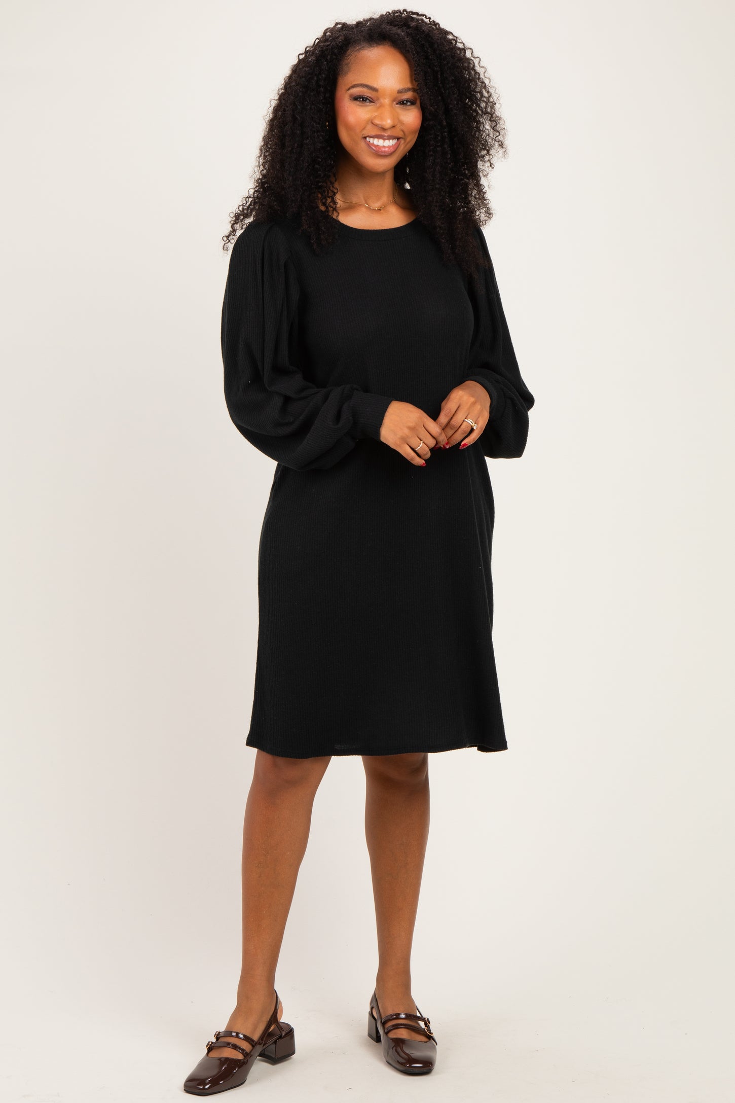woman wearing a black long sleeve ribbed dress with a relaxed fit and balloon sleeves