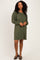 woman wearing an olive green sweater dress with puff sleeves and a relaxed fit