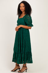 woman wearing a green lace maxi dress with short puff sleeves and a tiered hemline