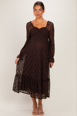 woman wearing a dark brown lace maternity dress with long sleeves and a ruffled hem, showing her baby bump