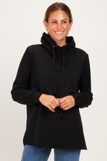 woman wearing a black long sleeve hoodie with a cowl neck and drawstring, smiling at the camera