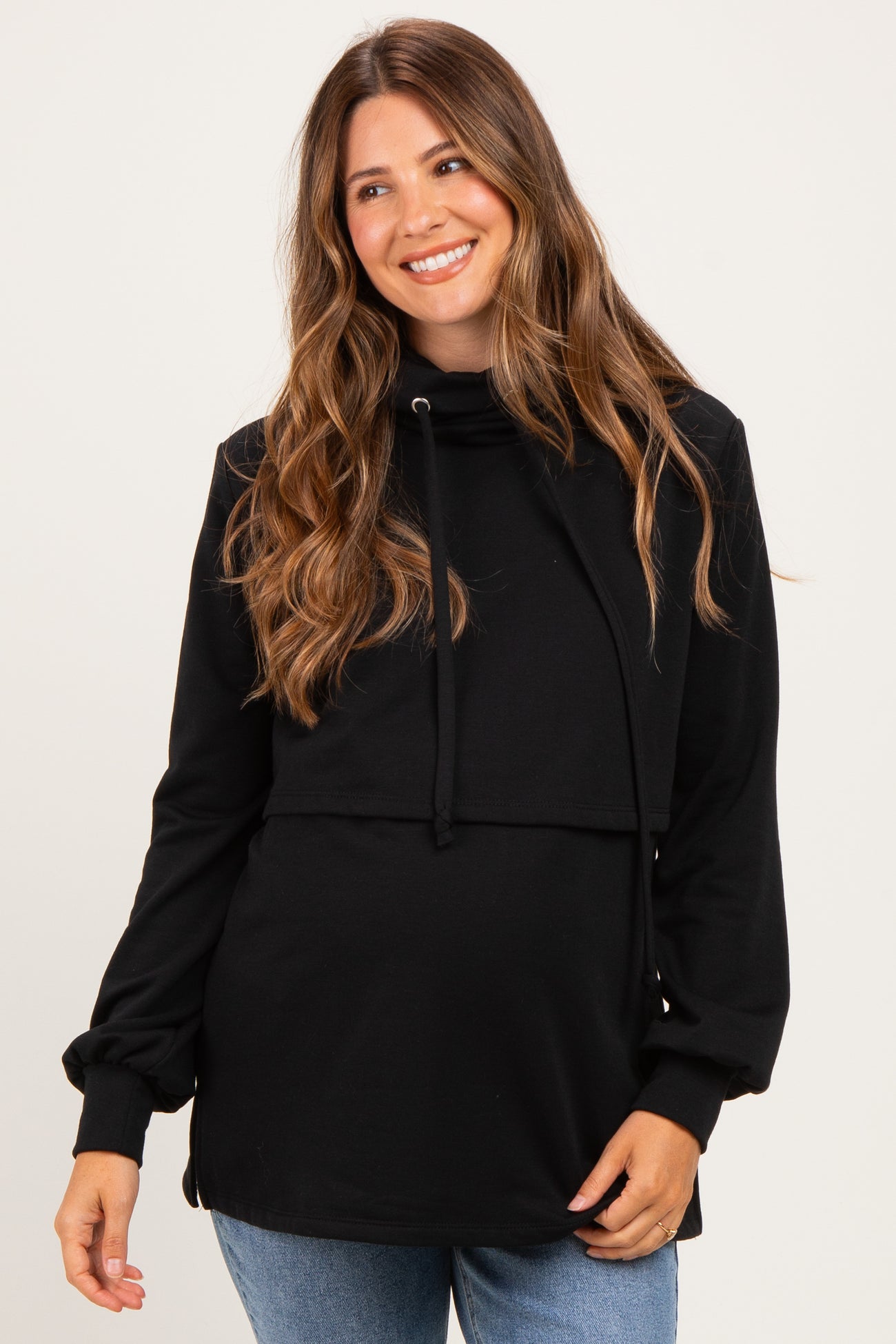 woman wearing a black maternity pullover sweatshirt with a cowl neck and drawstring detail, showing her baby bump