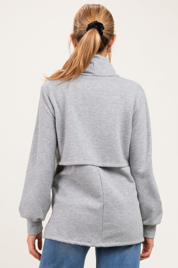 woman wearing a gray maternity pullover with a high collar and split back design, viewed from the back