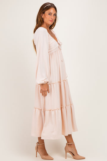 woman wearing a soft pink long sleeve midi dress with a tiered skirt and heels