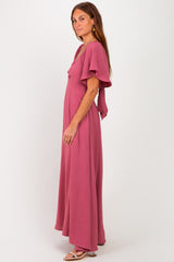 woman wearing a dusty rose maxi dress with flutter sleeves and a flowy silhouette