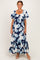 woman wearing a floral navy blue maxi dress with short sleeves and a tiered skirt