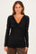 woman wearing a black long sleeve top with a draped neckline and ribbed texture