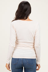 woman wearing a light pink long sleeve ribbed top and blue jeans, viewed from the back