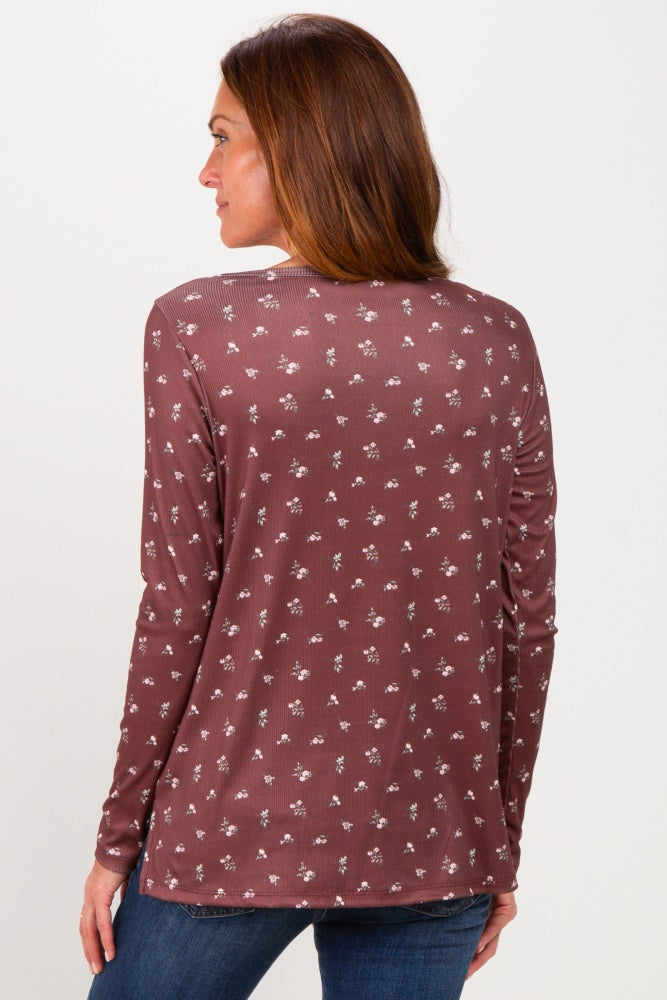 woman wearing a dark mauve long sleeve top with a floral print and a rounded neckline, seen from the back