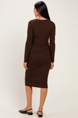 woman wearing a brown ribbed midi dress with long sleeves and a fitted silhouette, viewed from the back