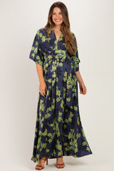 woman wearing a navy blue floral maternity maxi dress with a cinched waist and flutter sleeves, showcasing her baby bump
