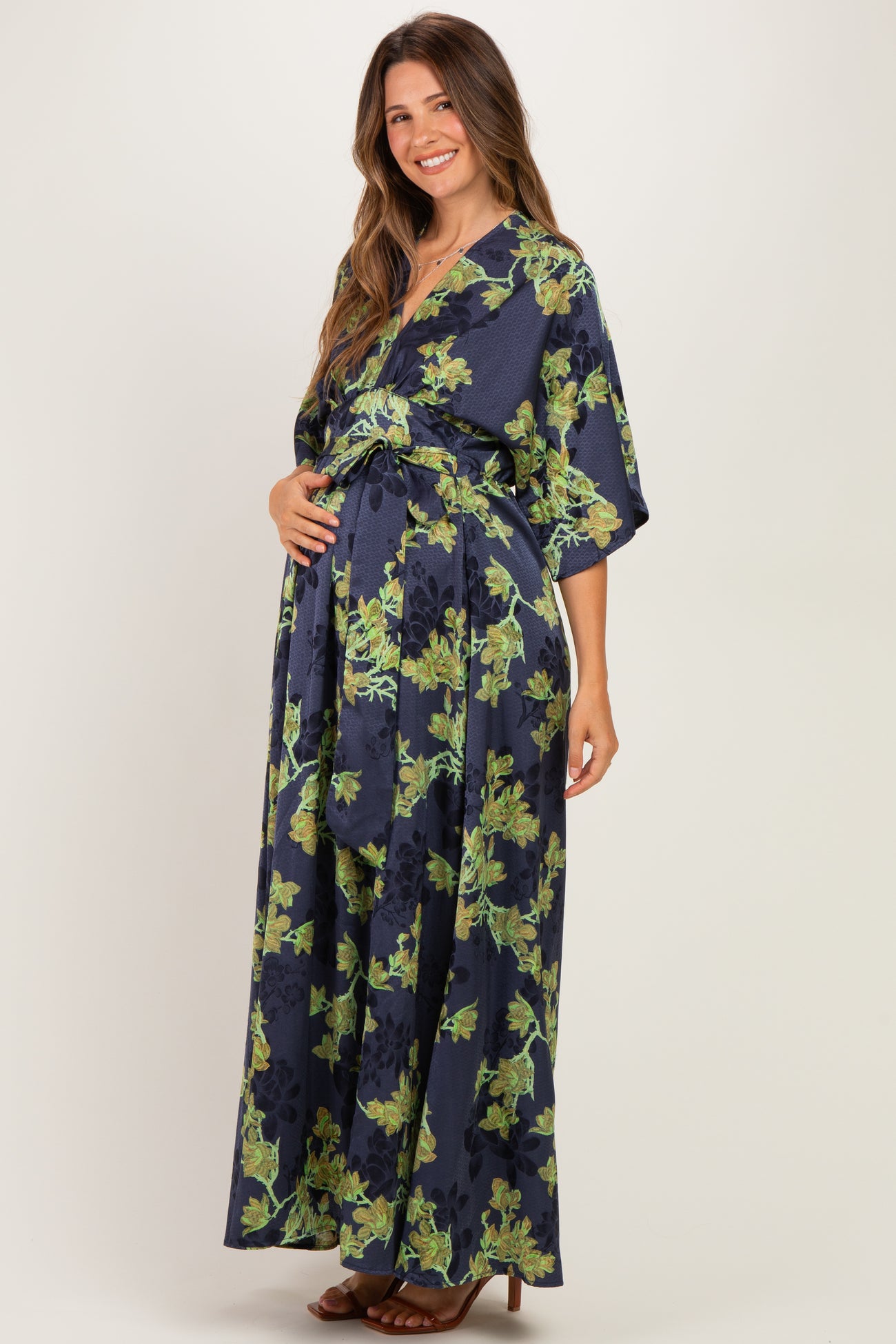 woman wearing a navy floral maternity maxi dress and holding her baby bump