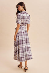 woman wearing a short sleeve purple and white plaid midi dress with a tie waist, viewed from the back