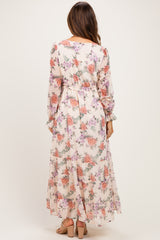 woman wearing a floral long sleeve maternity maxi dress with a flowing hem and gathered waist