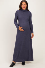 woman wearing a navy blue long sleeve maternity maxi dress and holding her baby bump