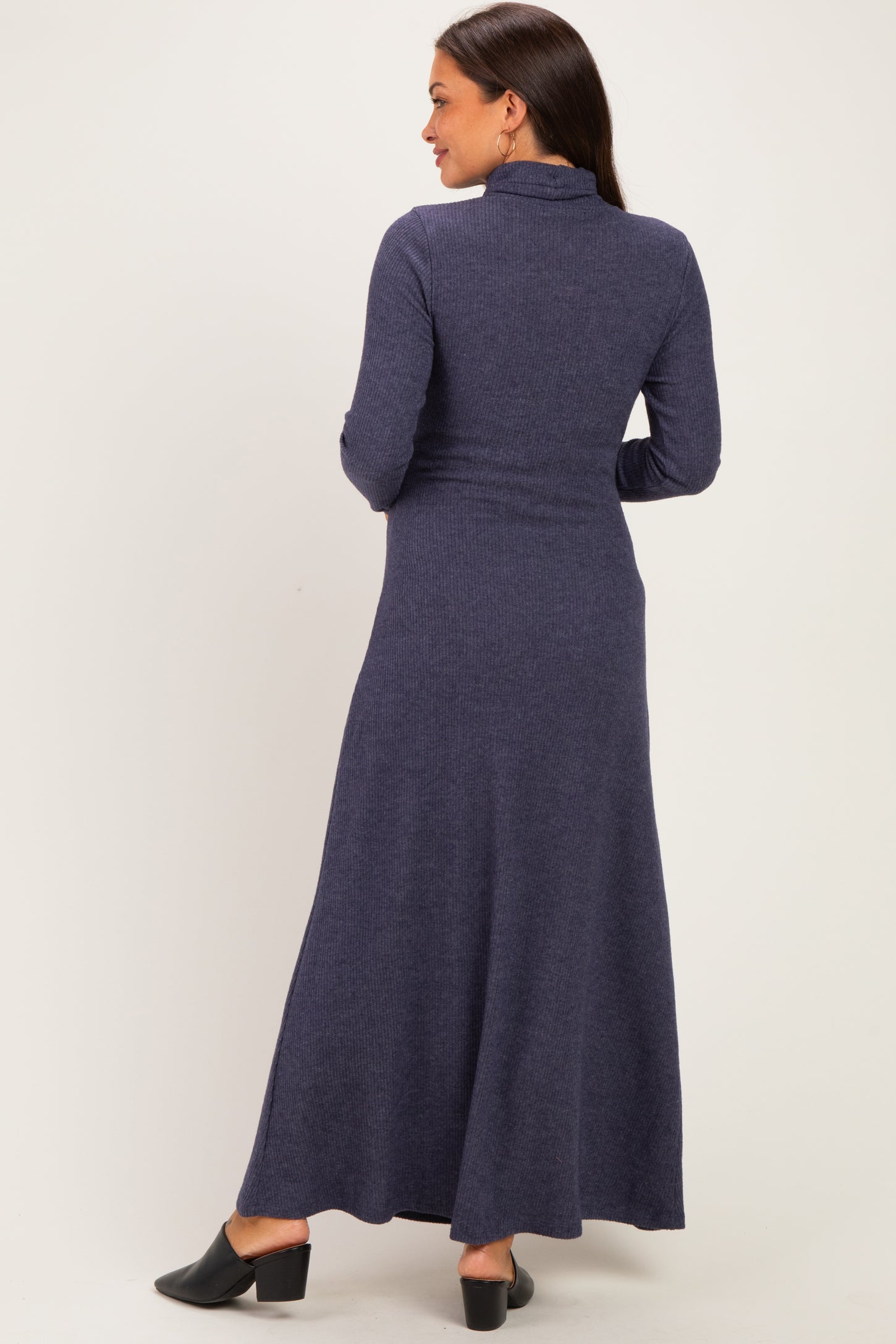 woman wearing a navy blue long sleeve maternity maxi dress, view from the back, showcasing a flowing silhouette