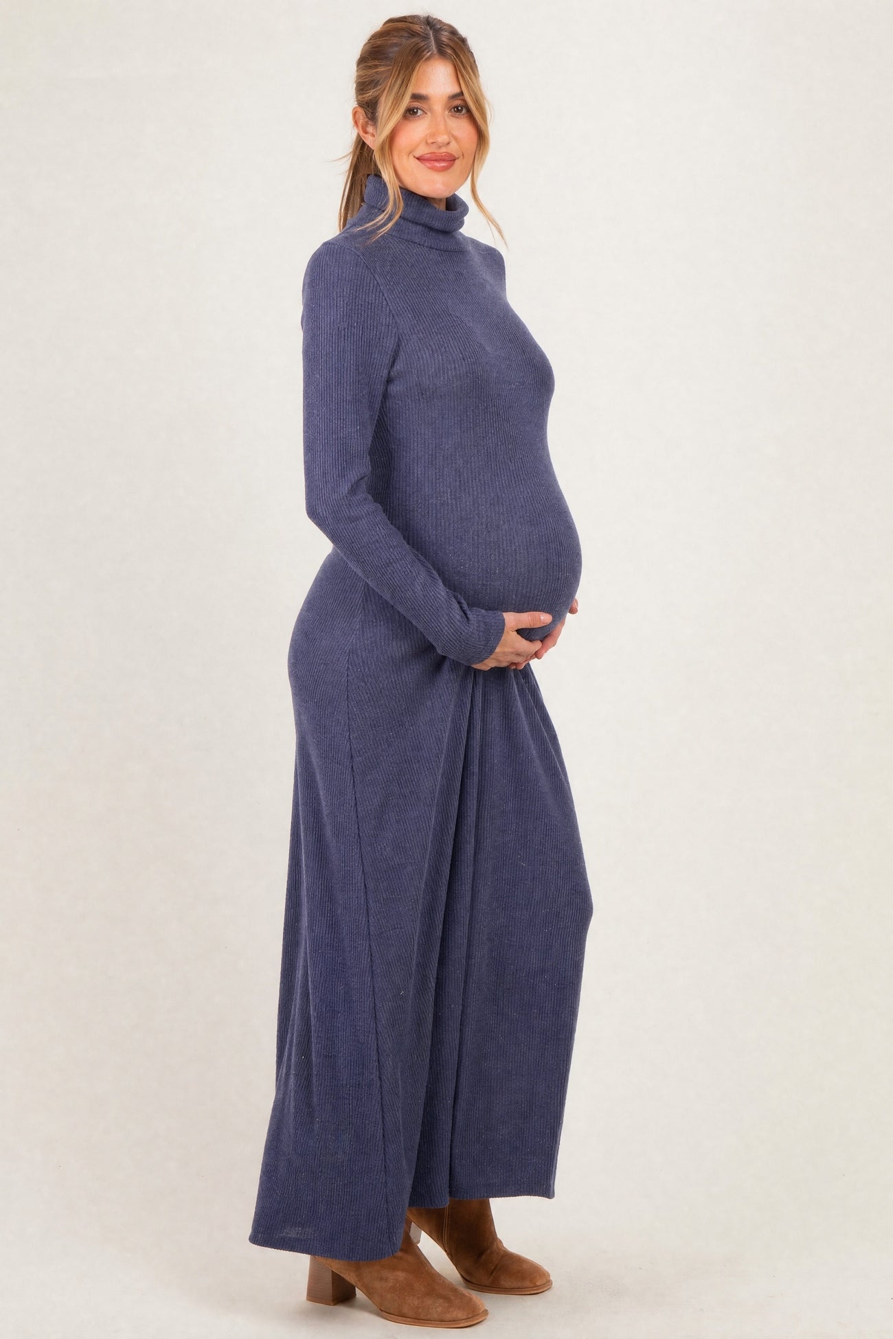woman wearing a navy long sleeve maternity dress with turtleneck and visible baby bump