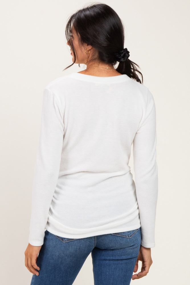 woman wearing a white long sleeve top, viewed from the back, paired with blue jeans