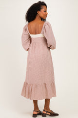 woman wearing a brown and white checkered midi dress with puff sleeves and a ruffle hem, showing the back view
