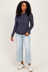 woman wearing a navy blue long sleeve henley top with buttons and light wash cropped jeans