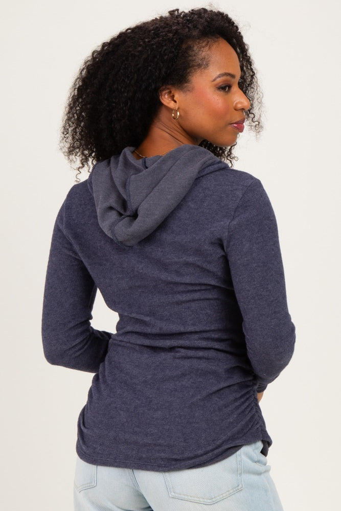woman wearing a navy long sleeve hooded top, shown from the back with a relaxed fit and curved hem
