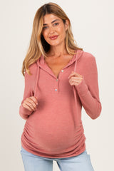 woman wearing a dusty rose maternity hoodie with a button-up front and a visible baby bump