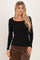 woman wearing a black long sleeve ribbed top with ruffle detailing and a square neckline