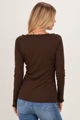 woman wearing a brown long sleeve top with a scalloped neckline and back view, paired with blue jeans