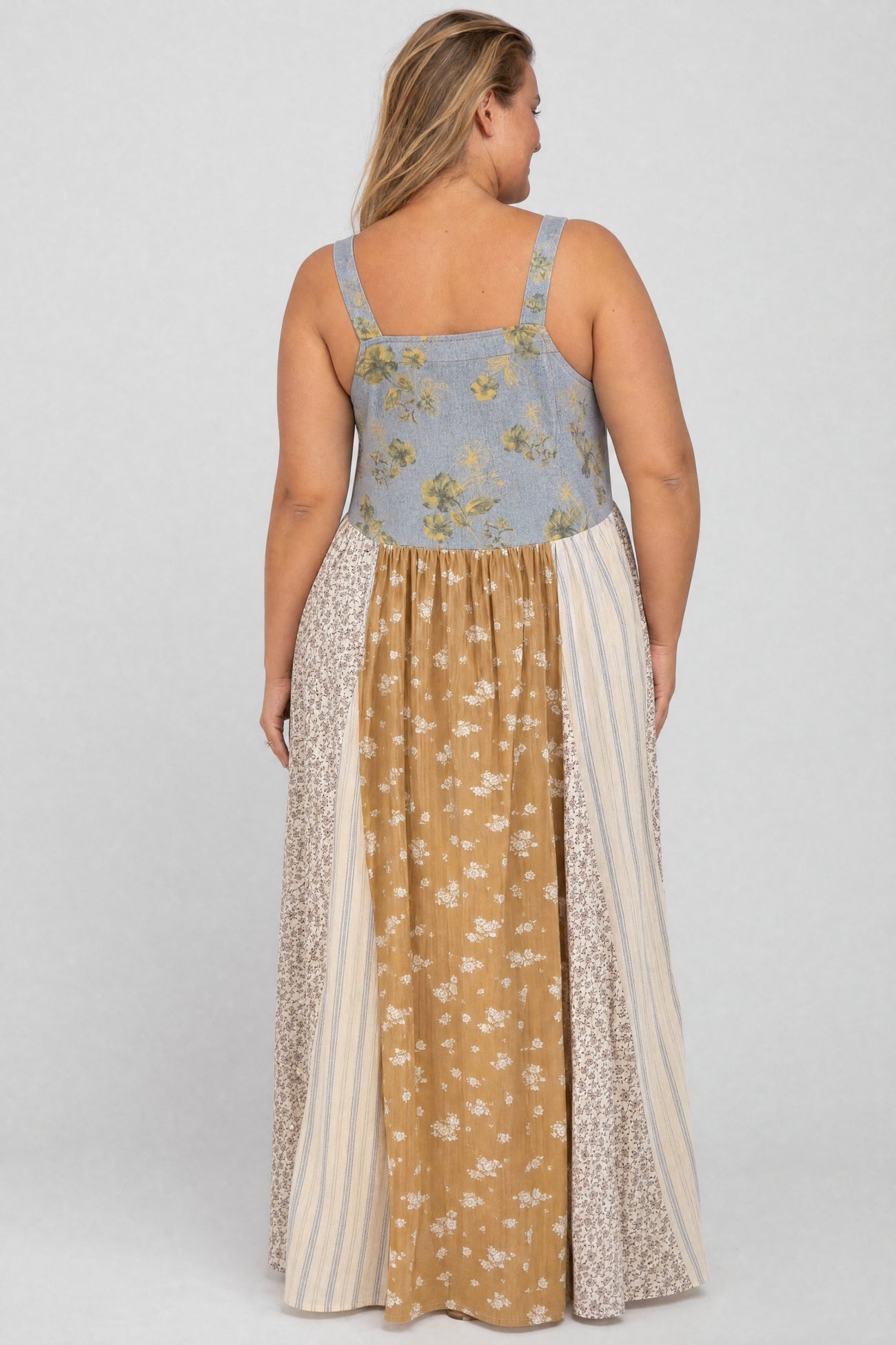 woman wearing a floral patterned maternity maxi dress with a blue top and multicolor skirt, showing her back