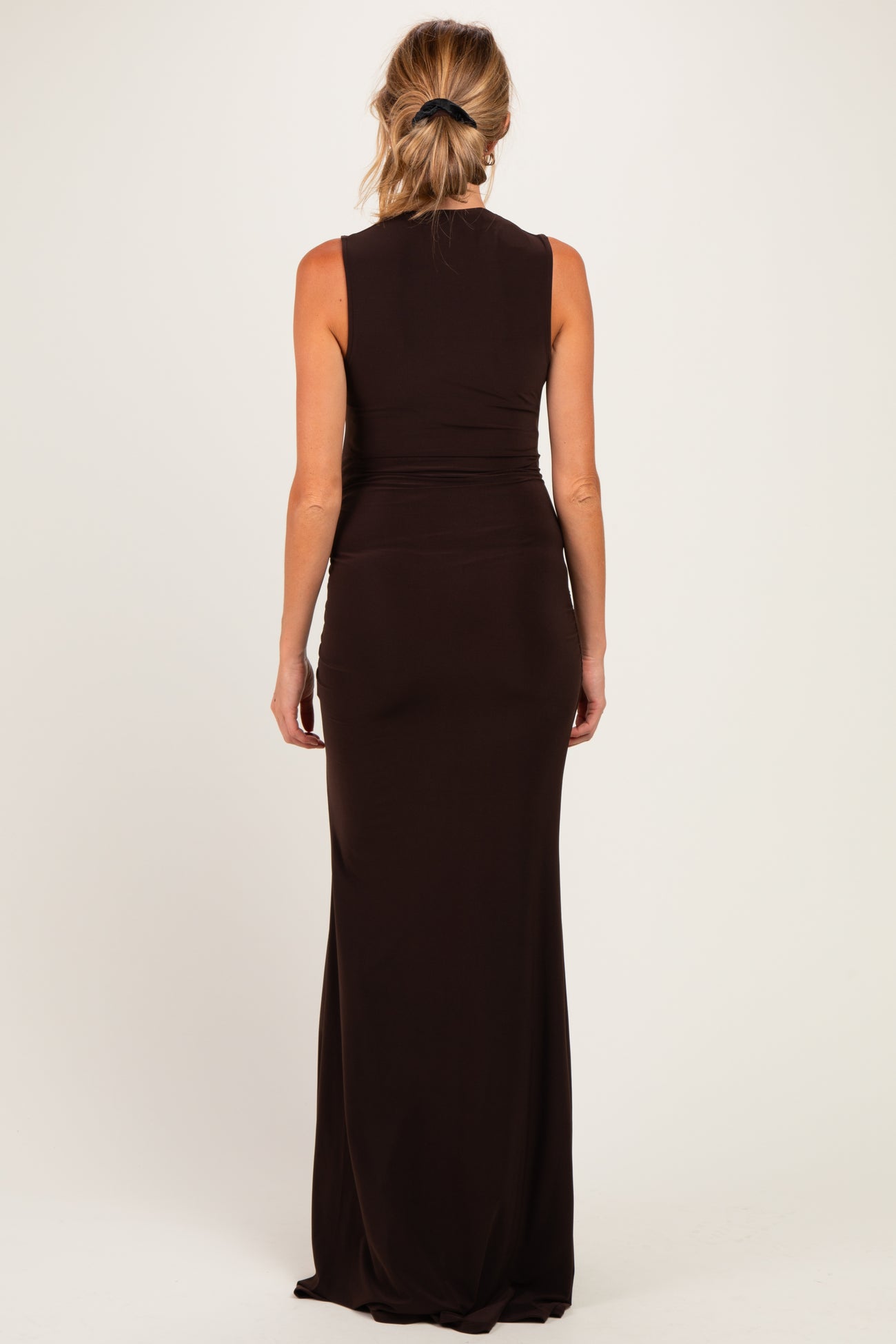 woman wearing a fitted black sleeveless maternity maxi dress, showing smooth back design