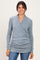 woman wearing a light blue wrap top with side ruching and long sleeves paired with blue jeans